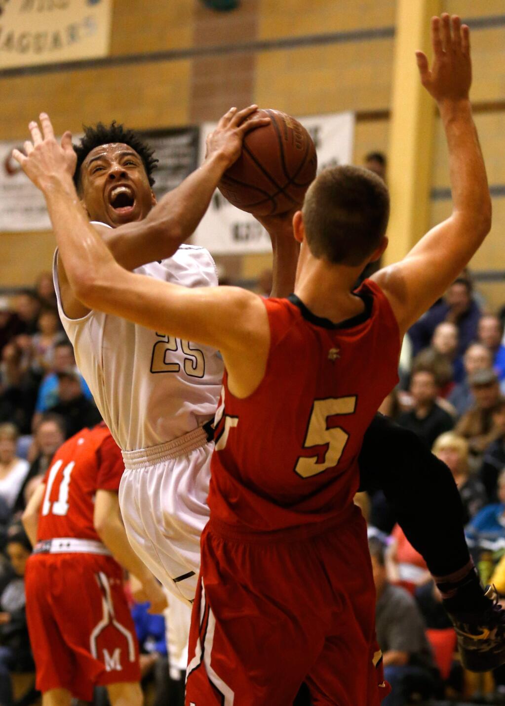 Windsor's Parker Canady (25), left, fights his way to the basket against Montgomery's Joel Seitz (5) during the first half of the NCS Division 2 boys basketball quarterfinal game between Montgomery and Windsor high schools in Windsor, California, on Friday, February 26, 2016. (Alvin Jornada / The Press Democrat)