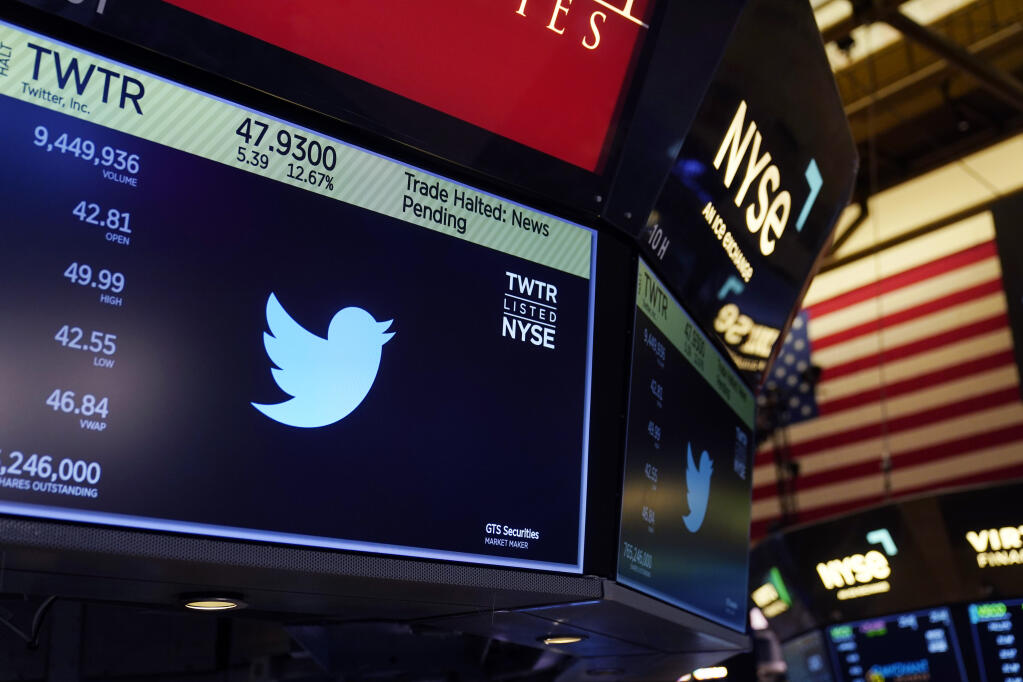 The symbol for Twitter appears above a trading post on the floor of the New York Stock Exchange, Tuesday, Oct. 4, 2022. Trading in shares of Twitter was halted after the stock spiked on reports that Elon Musk would proceed with his $44 billion deal to buy the company after months of legal battles.(AP Photo/Seth Wenig)