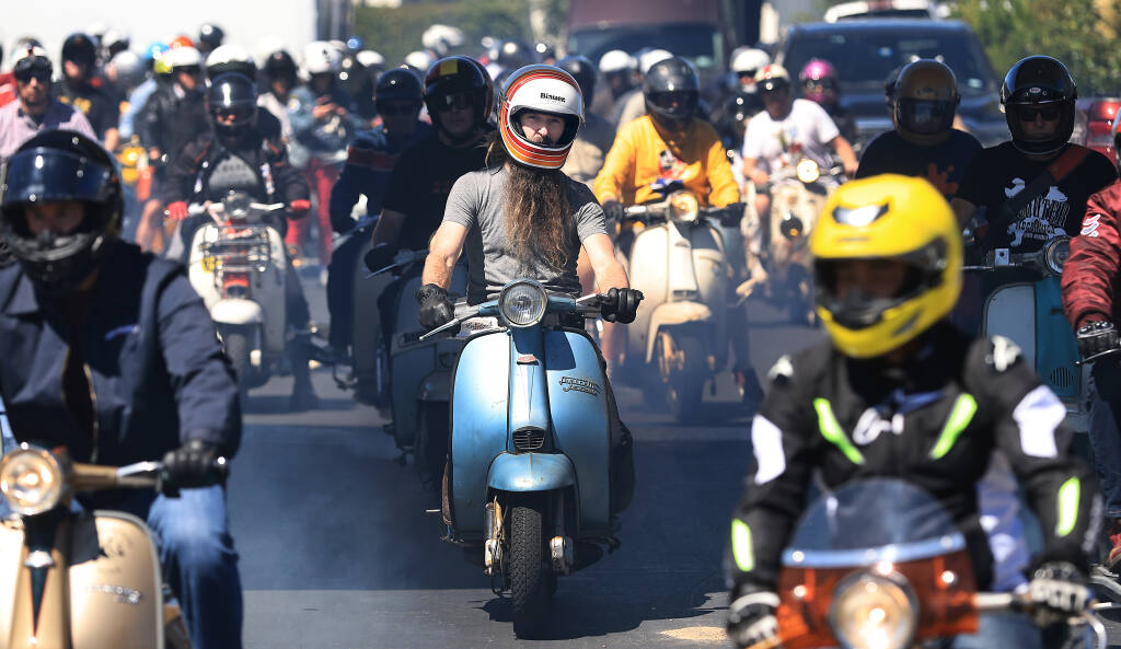 Participants of the Lambretta Jamboree leave the Sandman Hotel in Santa Rosa, Friday, July 8, 2022 for a ride around the rural areas of north and west Sonoma County. Hundreds of riders, aficionados of the famed Italian scooter, are in the county through Sunday.   (Kent Porter / The Press Democrat) 2022