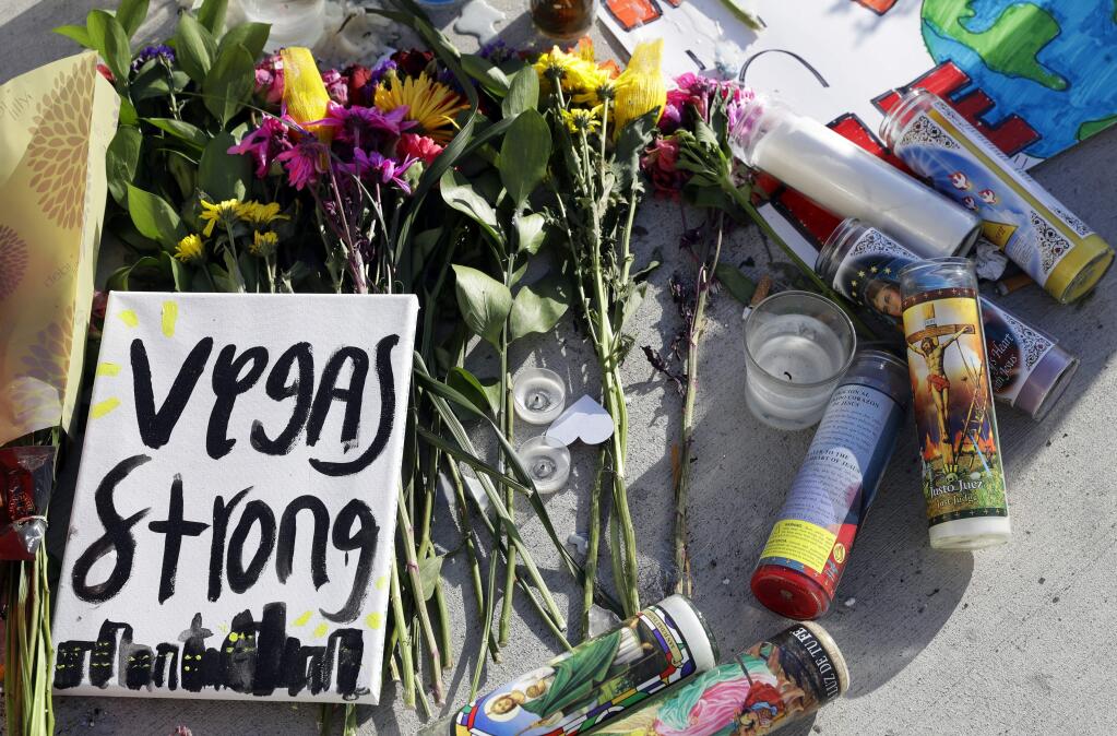 Flowers and signs are left at a makeshift memorial for the victims of a mass shooting in Las Vegas, Wednesday, Oct. 4, 2017, in Las Vegas. (AP Photo/Marcio Jose Sanchez)