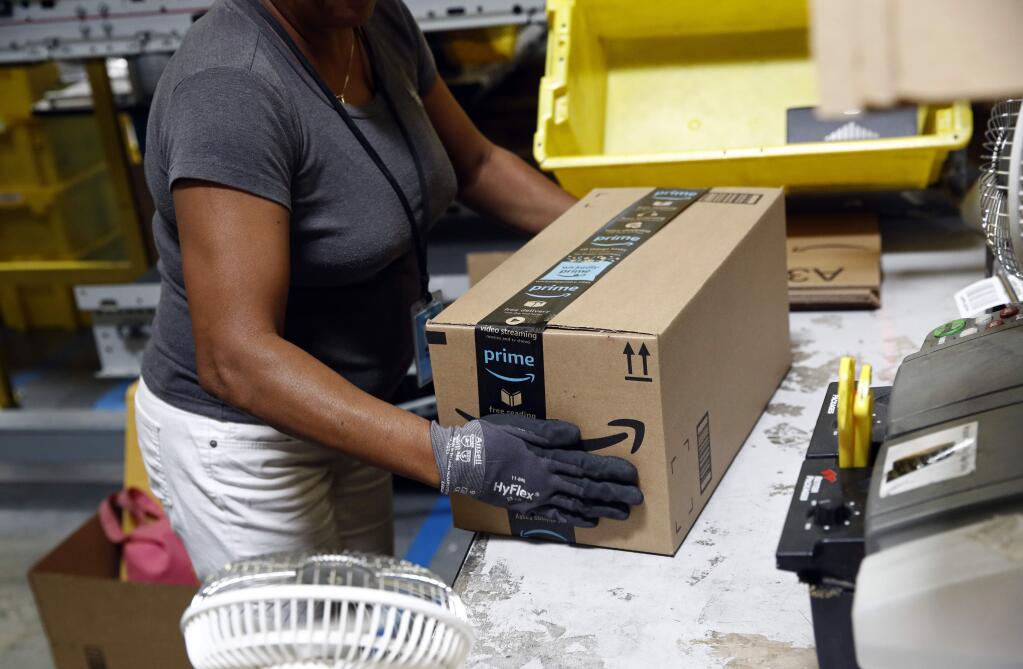 FILE- In this Aug. 3, 2017, file photo, Myrtice Harris applies tape to a package before shipment at an Amazon fulfillment center in Baltimore. Amazon's Prime Day starts July 16, 2018, and will be six hours longer than last year's and will launch new products. (AP Photo/Patrick Semansky, File)