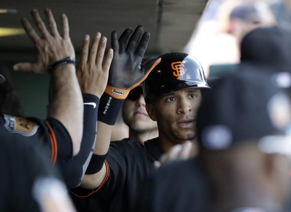 The San Francisco Giants' Gorkys Hernandez is congratulated after scoring during the fourth inning of a spring game against the Cincinnati Reds, Monday, March 27, 2017, in Scottsdale, Ariz. (AP Photo/Darron Cummings)