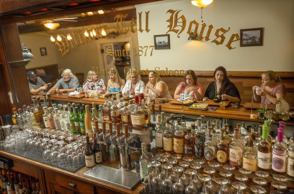 Local friends enjoy a drink and appetizers at the bar at the William Tell House in Tomales. (John Burgess/The Press Democrat)