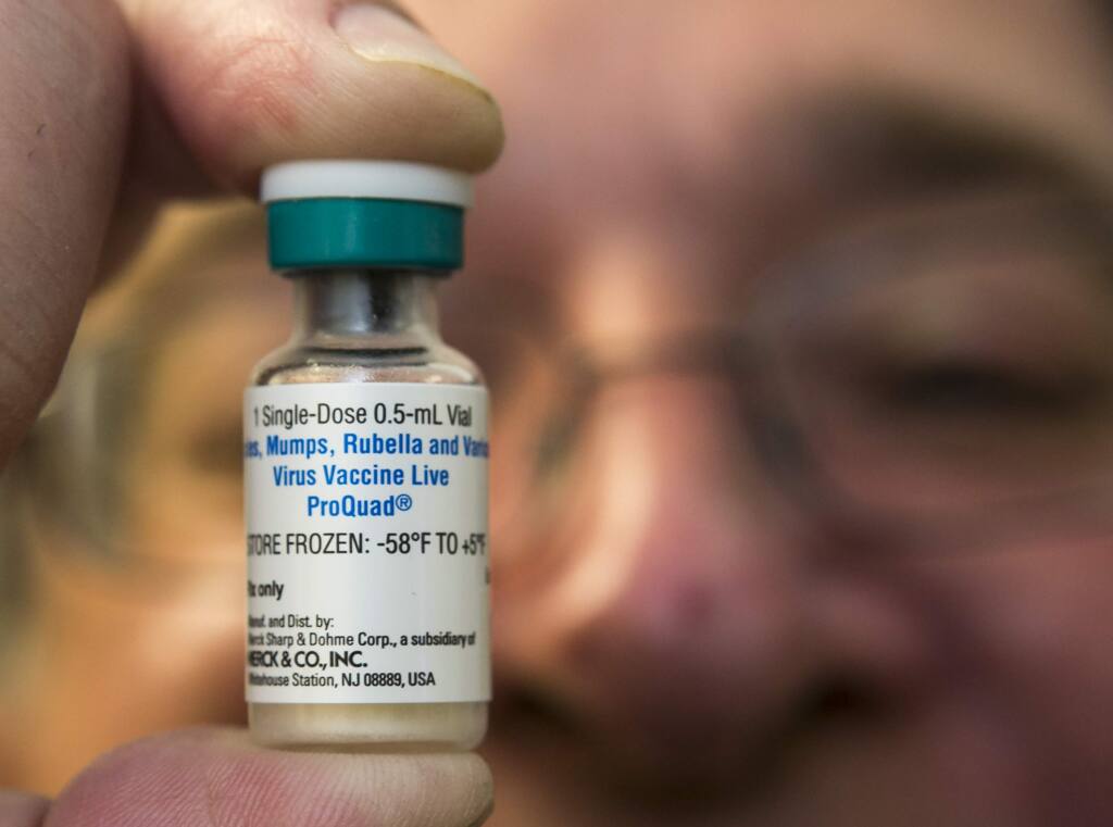 In this Thursday, Jan. 29, 2015 photo, a pediatrician holds a dose of the measles-mumps-rubella (MMR) vaccine at his practice in Northridge, Calif. Vaccinations can cause minor side effects including redness at the injection site and sometimes mild fever, but medical experts say serious complications are rare and much less dangerous than the diseases that vaccines prevent. (AP Photo/Damian Dovarganes)
