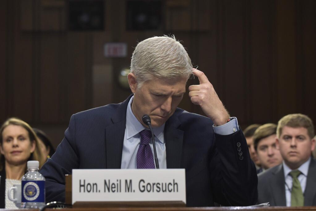 Supreme Court nominee Neil Gorsuch looks over a document during the second day of his Senate confirmation hearing. (SUSAN WALSH / Associated Press)
