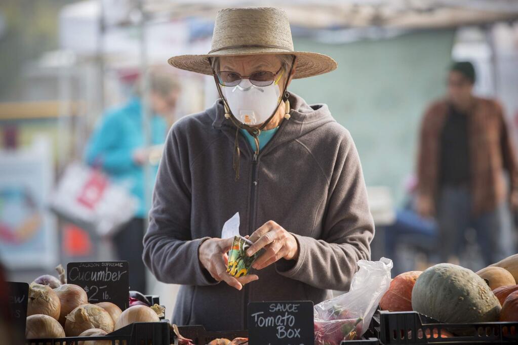 Claudia Robbins wears a protective face mask at Friday's farmers market, on Nov. 16. As smoke from the Camp Fire shrouds the Valley donning masks to filter air particulates is becoming a common sight. (Photo by Robbi Pengelly/Index-Tribune)