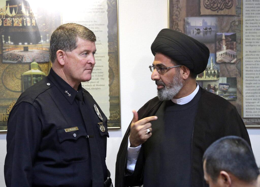 Los Angeles Police Deputy Chief Michael Downing talks with Sayed Moustafa al-Qazwini, founding Imam of the Islamic Educational Center of Orange County at a news conference at the Islamic Center of Southern California in Los Angeles Monday, Nov. 28, 2016. Government officials have condemned a hate-filled letter received by several California mosques that said Muslims would be exterminated by President-elect Donald Trump. Downing said that Los Angeles police are investigating two letters received by mosques in the city as a hate incident, but not a crime at this point. (AP Photo/Nick Ut)