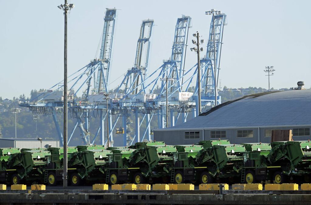 John Deere Agricultural machinery made by Deere & Company sits staged for transport, Friday, May 10, 2019, near cranes at the Port of Tacoma in Tacoma, Wash. U.S. and Chinese negotiators resumed trade talks Friday under increasing pressure after President Donald Trump raised tariffs on $200 billion in Chinese goods and Beijing promised to retaliate. (AP Photo/Ted S. Warren)