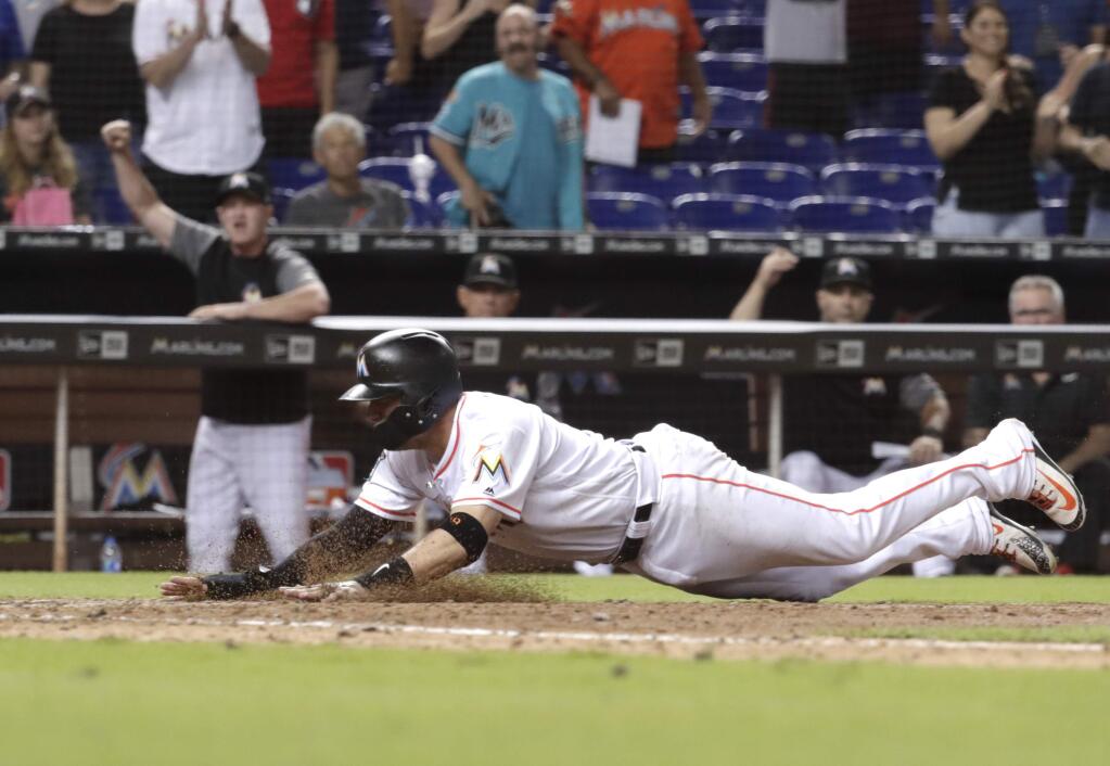 The Miami Marlins' Miguel Rojas scores the game-winning run on a sacrifice fly by Brian Anderson during the ninth inning against the San Francisco Giants, Wednesday, June 13, 2018, in Miami. The Marlins won 5-4. (AP Photo/Lynne Sladky)