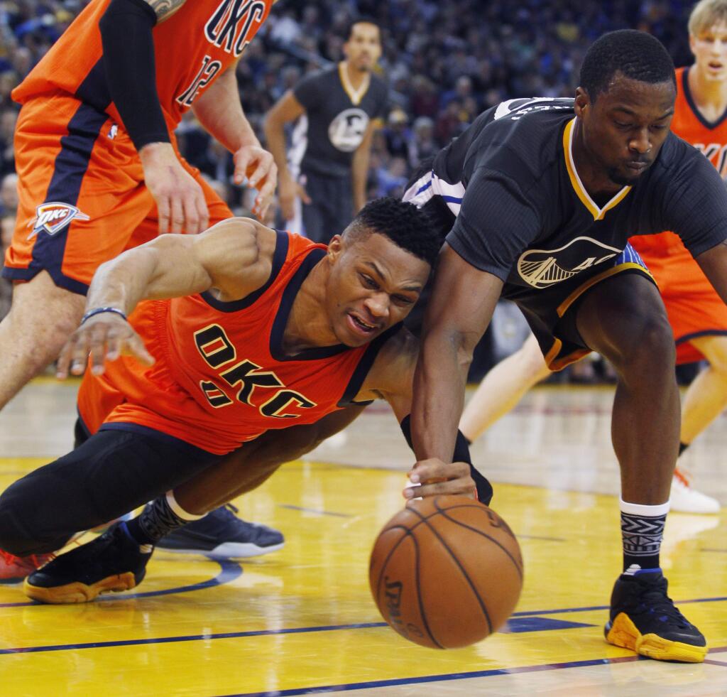 Oklahoma City Thunder's Russell Westbrook, left, and Golden State Warriors' Harrison Barnes struggle for a loose ball during the first half of an NBA basketball game Saturday, Feb. 6, 2016, in Oakland, Calif. (AP Photo/George Nikitin)