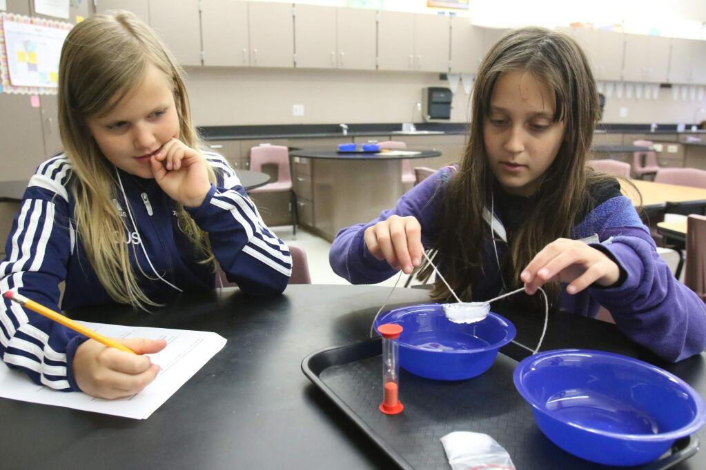Ashlyn Byous, left, and Maya Scholnick of McKinley School in Petaluma conduct a science experiment during the Sonoma County Science Olympiad at Lawrence E Jones Middle School in Rohnert Park on Saturday, April 16, 2016. (SCOTT MANCHESTER/ARGUS-COURIER STAFF)