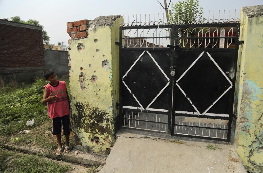 An Indian boy looks at a house damaged by firing, allegedly from the Pakistan side of the border, near the International Border in Arnia village near, about 47 kilometers (30 miles) from Jammu, India, Friday, Sept. 22, 2017. Schools in the international border area have been closed and residents are moving to safer areas as firing continued in the region. India and Pakistan have a long history of bitter relations over Kashmir. They have fought two of their three wars over the region since they gained independence from British colonial rule in 1947. (AP Photo /Channi Anand)