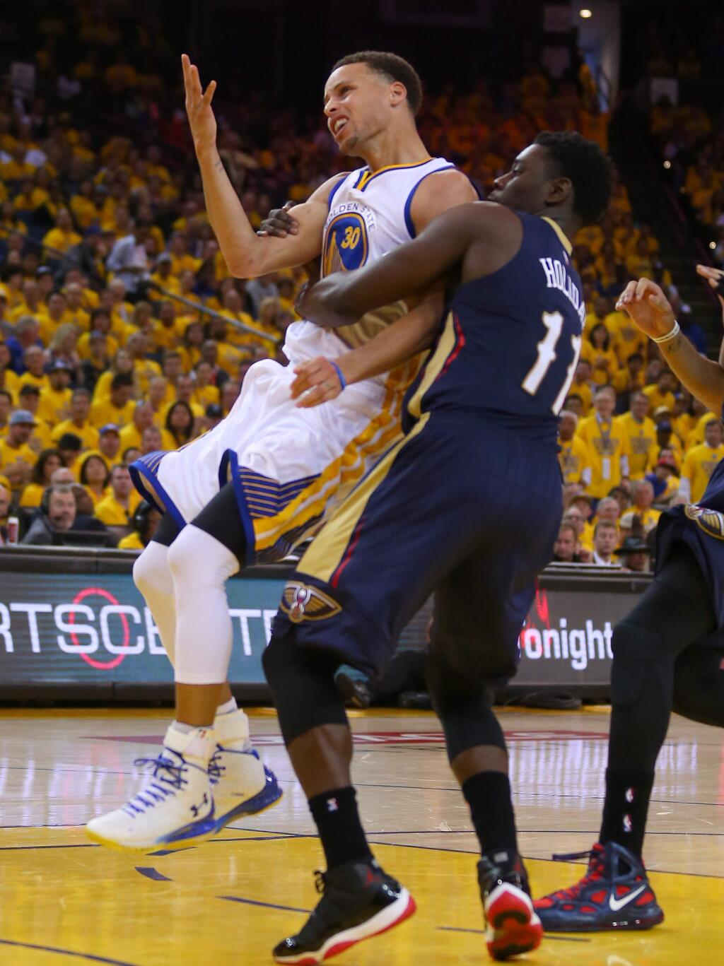 New Orleans Pelicans guard Jrue Holiday intentionally fouls Golden State Warriors guard Stephen Curry to prevent a breakaway basket during Game 1 of the first round of the NBA Western Conference playoffs at Oracle Arena, in Oakland on Saturday, April 18, 2015. The Warriors defeated the Pelicans 106-99.(Christopher Chung/ The Press Democrat)