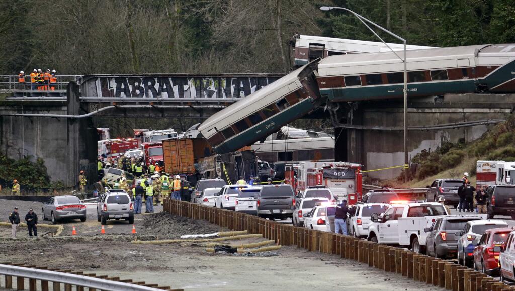 Cars from a derailed Amtrak train lay spilled onto Interstate 5 near Tacoma, Washington on Dec. 18. (ELAINE THOMPSON / Associated Press)