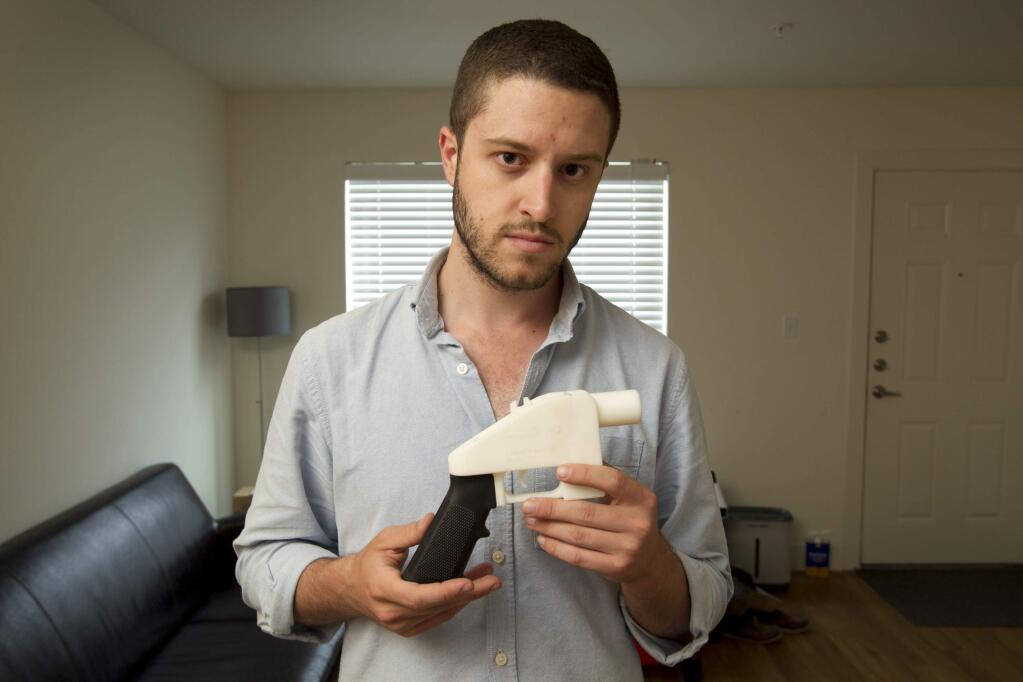 FILE - In this May 10, 2013, file photo, Cody Wilson, the founder of Defense Distributed, shows a plastic handgun made on a 3D-printer at his home in Austin, Texas. Eight states filed suit Monday, July 30, 2018, against the Trump administration over its decision to allow a Texas company to publish downloadable blueprints for a 3D-printed gun, contending the hard-to-trace plastic weapons are a boon to terrorists and criminals and threaten public safety. (Jay Janner/Austin American-Statesman via AP, File)