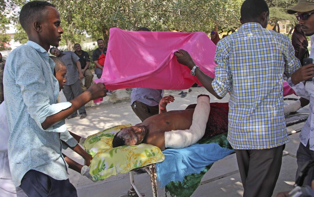 Somalis help a civilian wounded in Saturday's blast, at Medina hospital in Mogadishu, Somalia Sunday, Oct. 15, 2017. (AP Photo/Farah Abdi Warsameh)