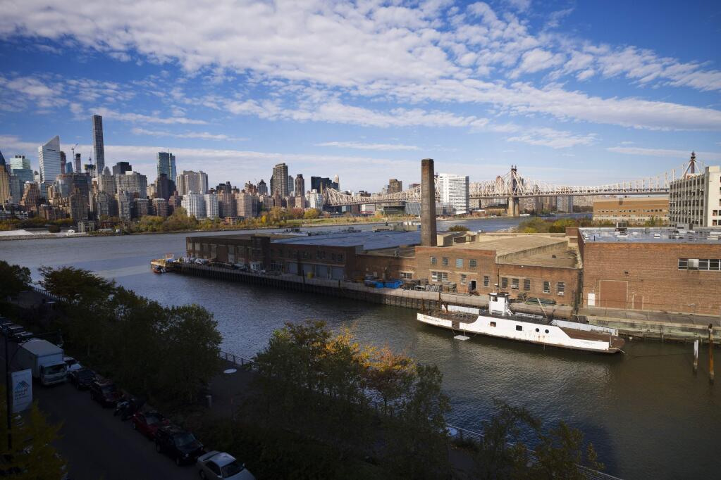 FILE- In this Nov. 7, 2018, file photo, a rusting ferryboat is docked next to an aging industrial warehouse on Long Island City's Anable Basin in the Queens borough of New York. Amazon said Thursday, Feb. 14, 2019, that it is dropping New York City as one of its new headquarter locations. (AP Photo/Mark Lennihan, File)
