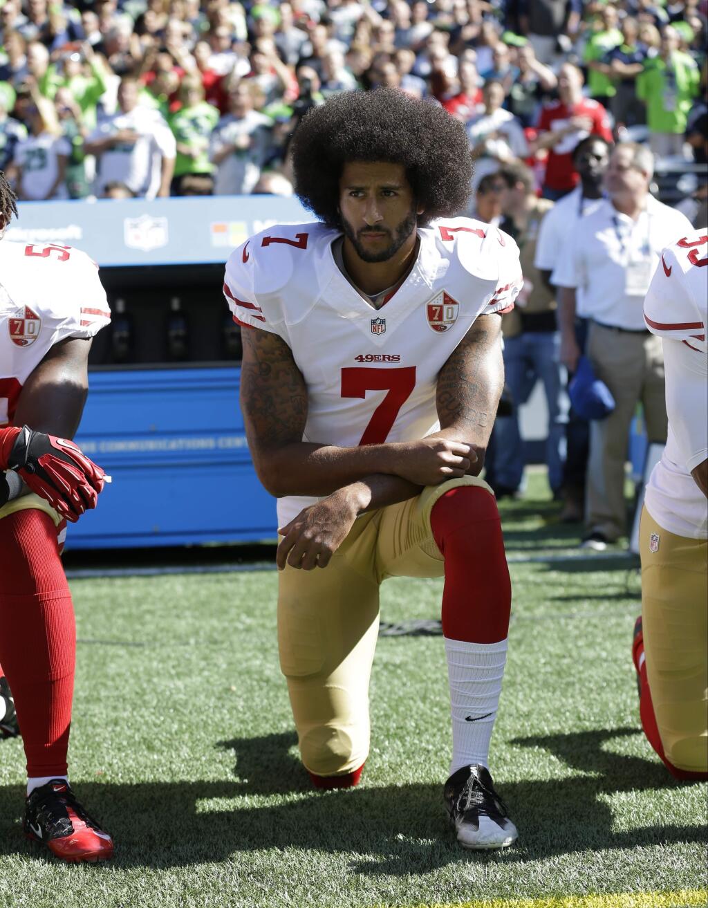 FILE - In this Sept. 25, 2016, file photo, San Francisco 49ers' Colin Kaepernick kneels during the national anthem before an NFL football game against the Seattle Seahawks, in Seattle. Kaepernick has a new deal with Nike, even though the NFL does not want him. Kaepernick's attorney, Mark Geragos, made the announcement on Twitter, calling the former 49ers quarterback an “All American Icon” and crediting attorney Ben Meiselas for getting the deal done. (AP Photo/Ted S. Warren, File)
