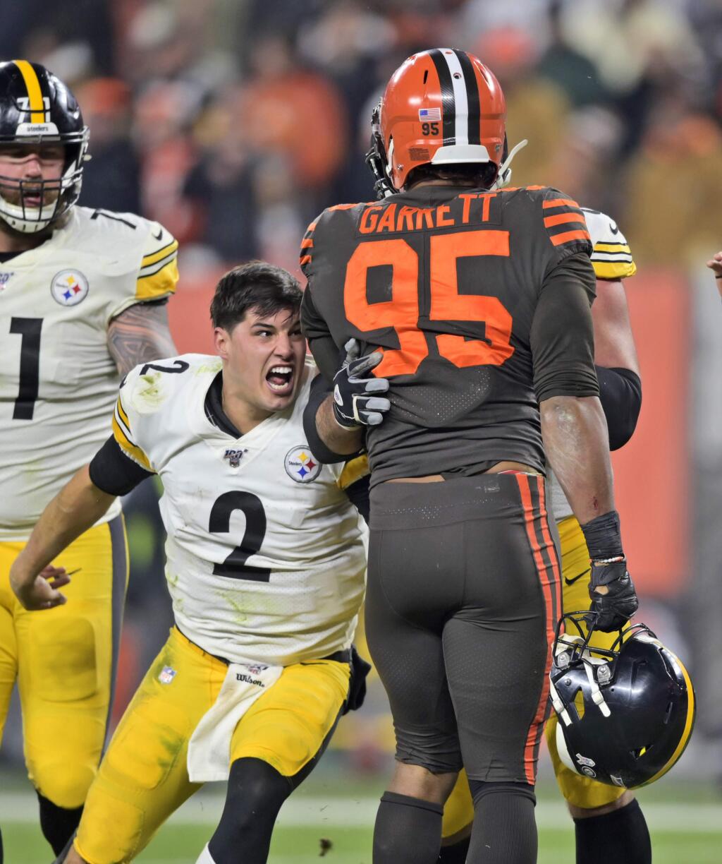 Pittsburgh Steelers quarterback Mason Rudolph (2) goes after Cleveland Browns defensive end Myles Garrett (95) during the second half of an NFL football game Thursday, Nov. 14, 2019, in Cleveland. The Browns won 21-7. (AP Photo/David Richard)