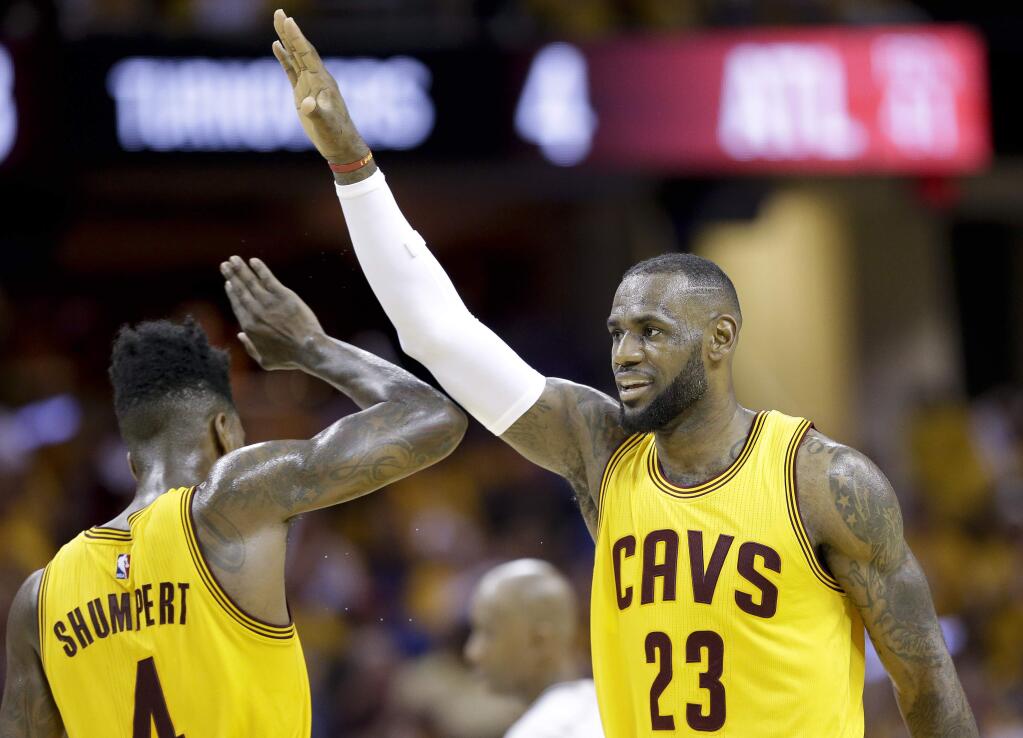 Cleveland Cavaliers forward LeBron James (23) high fives guard Iman Shumpert (4) during a timeout in the first half of Game 4 of the NBA basketball Eastern Conference Finals against the Atlanta Hawks Tuesday, May 26, 2015, in Cleveland. (AP Photo/Tony Dejak)