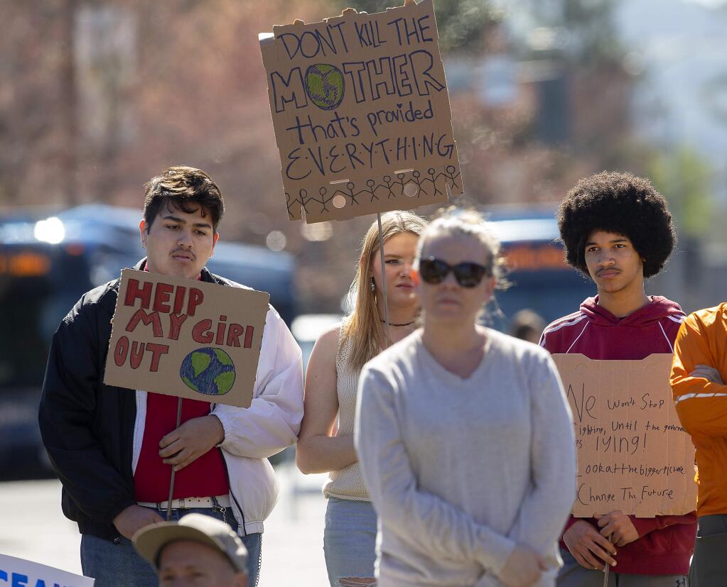 Students painted signs and their arms to demand action against climate change during a rally in Courthouse Square in Santa Rosa on Friday. The rally was a coordinated event with students around the U.S. and the world. (photo by John Burgess/The Press Democrat)