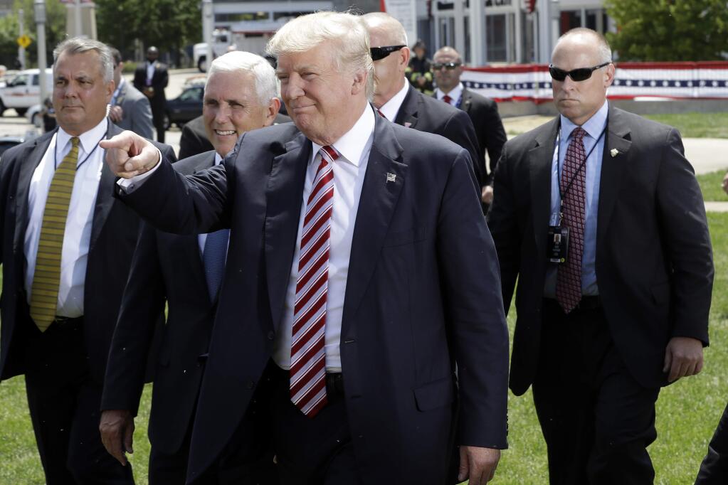 Republican presidential candidate Donald Trump, right, and Republican vice presidential candidate Gov. Mike Pence, R-Ind., walk toward supporters after Trump arrived via helicopter in Cleveland, Wednesday, July 20, 2016. (AP Photo/Mary Altaffer)