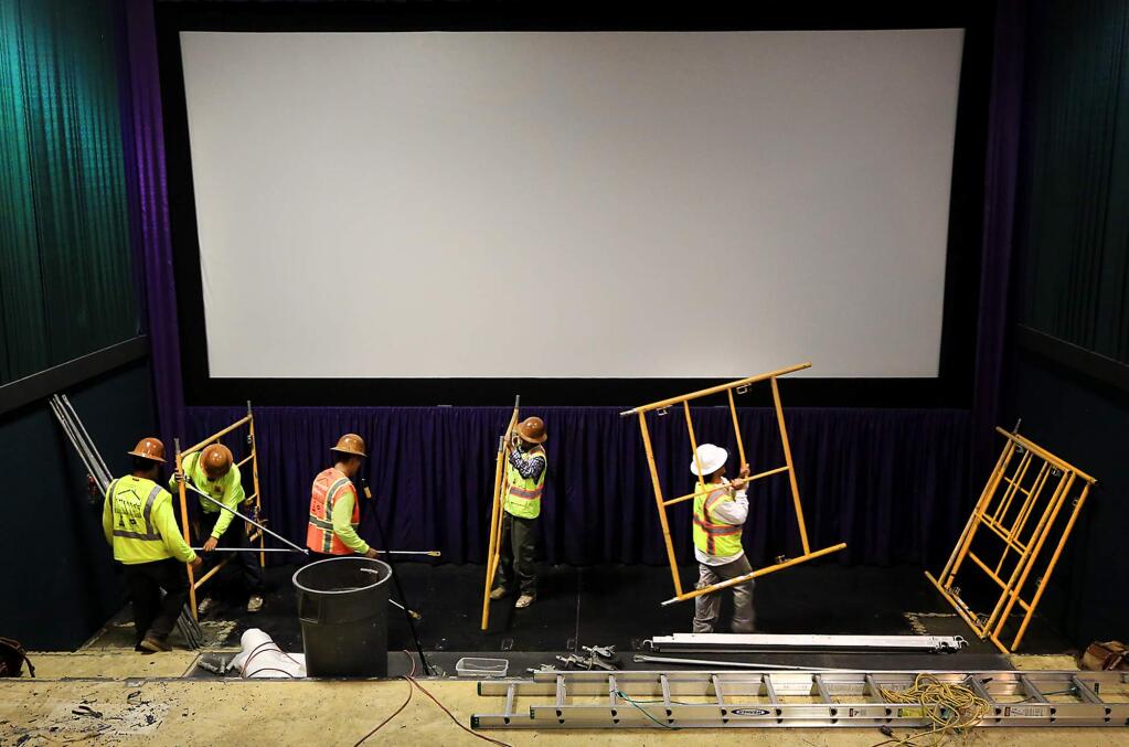 Workers with National Commercial Builders prepare scaffolding used to cover movie screens with plastic as they prepare one of the Airport Cinemas 12 Theater's for reclining seats, Wednesday June 14, 2017 in Windsor. (Kent Porter / Press Democrat) 2017