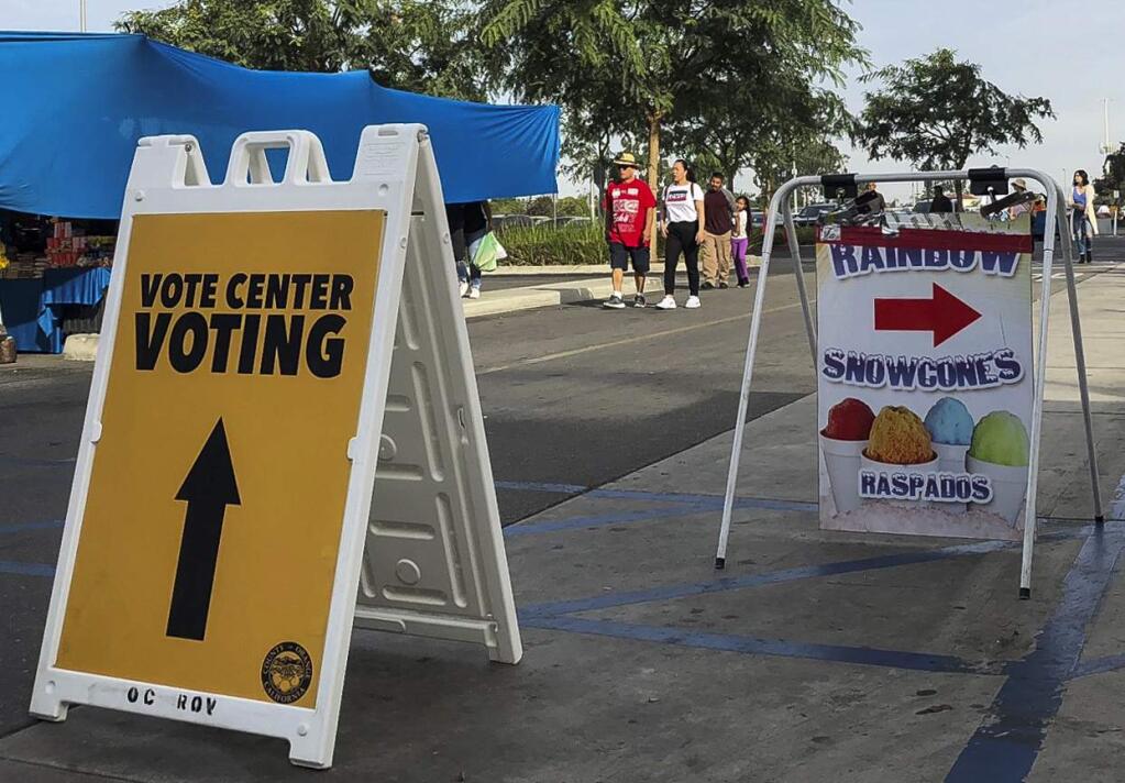 An Orange County registrar pop up voting location is seen at the Golden West College in Huntington Beach, Calif., Sunday, Nov. 4, 2018. The county registrar of voters has set up pop-up mobile voting locations around the county, including at a community college campus in Huntington Beach that hosts an outdoor market popular with the area's Vietnamese American and Latino communities. A handful of voters waited to cast ballots early in the morning at the pop up location next to the market, and some said they wanted to vote early to be sure their vote counted and avoid any Election Day lines. (AP Photo/Amy Taxin)
