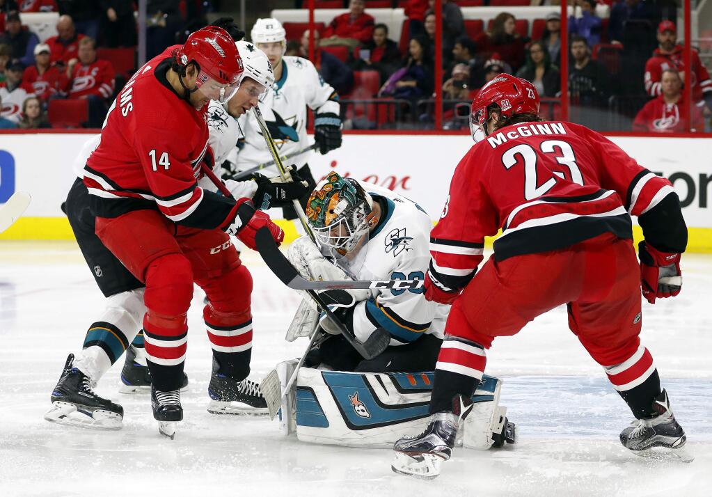 Carolina Hurricanes' Justin Williams (14) and teammate Brock McGinn (23) battle San Jose Sharks' Aaron Dell (30) and Justin Braun (61) for the puck during the second period of an NHL hockey game, Sunday, Feb. 4, 2018, in Raleigh, N.C. (AP Photo/Karl B DeBlaker)