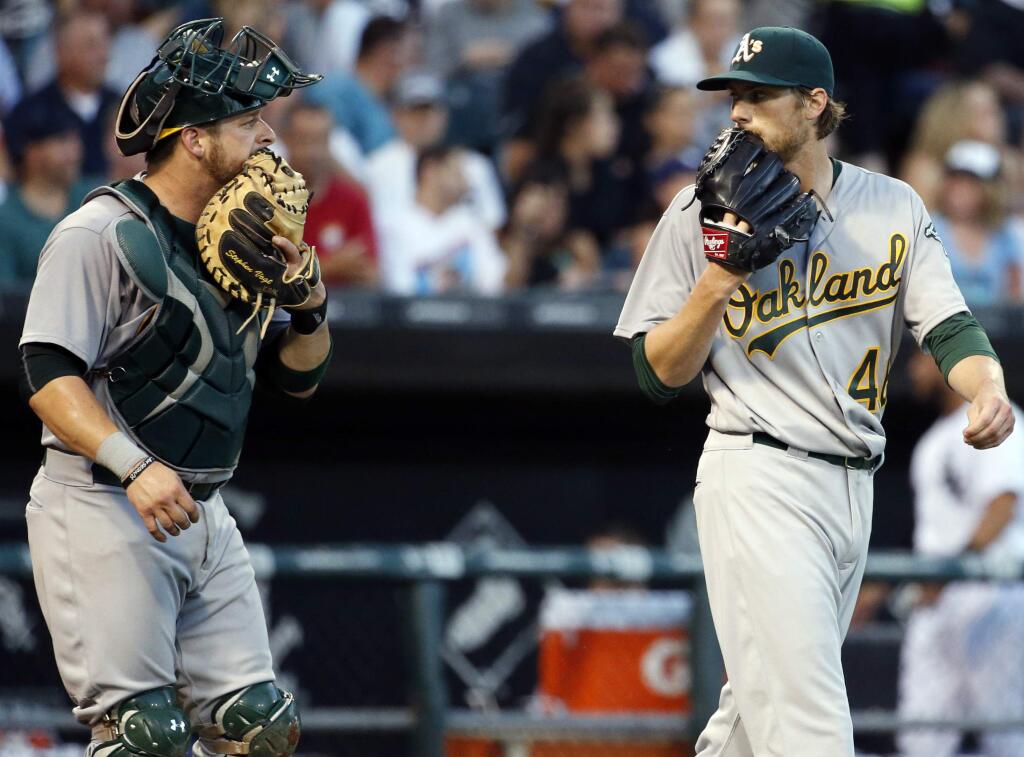 Oakland Athletics catcher Stephen Vogt, left, talks with pitcher Ross Detwiler during the fourth inning against the Chicago White Sox in Chicago, Saturday, Aug. 20, 2016. (AP Photo/Nam Y. Huh)