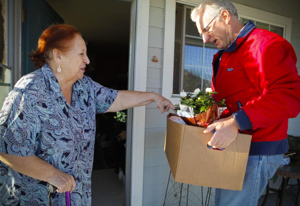 Petaluma, CA, USA. Friday, December 16, 2016._ Jim Thomas, a volunteer with Christmas Cheer delivers boxes to Teresa Froschi, 85. (CRISSY PASCUAL/ARGUS-COURIER STAFF)