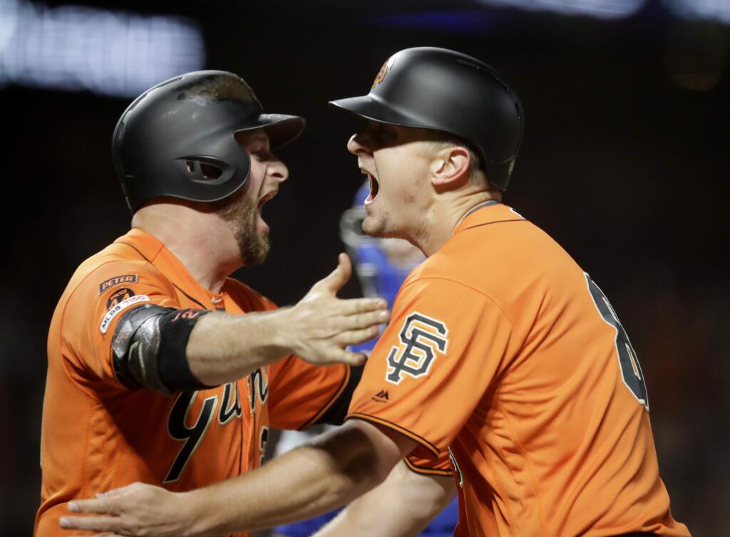 The San Francisco Giants' Alex Dickerson, right, celebrates with Stephen Vogt after scoring the winning run in the 10th inning against the New York Mets on Friday, July 19, 2019, in San Francisco. (AP Photo/Ben Margot)