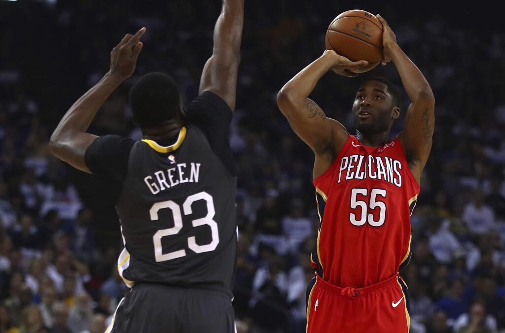 The New Orleans Pelicans' E'Twaun Moore, right, shoots against the Golden State Warriors' Draymond Green during the first half Saturday, April 7, 2018, in Oakland. (AP Photo/Ben Margot)