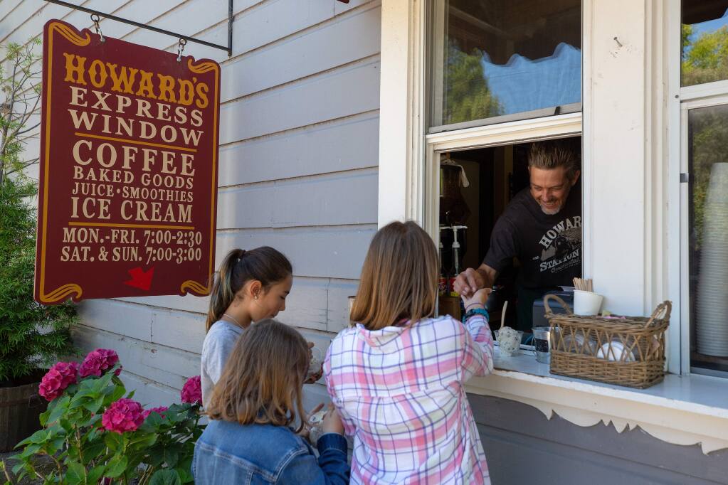 Barista Derek Voges helps kids with their ice cream orders at the Howard's Station Cafe Express Window, in Occidental, California, on Wednesday, July 24, 2019. (Alvin Jornada / The Press Democrat)