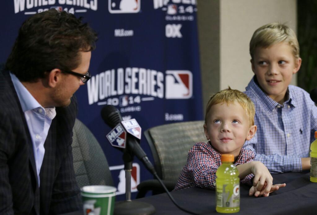 San Francisco Giants pitcher Jake Peavy, left, watches as his son Judson, center, and Wyatt, right, respond to a question about who their favorite player is during a news conference, Monday, Oct. 27, 2014, in Kansas City, Mo. The Giants are scheduled to play the Kansas City Royals in Game 6 of the baseball World Series in Kansas City on Tuesday. (AP Photo/Charlie Neibergall)