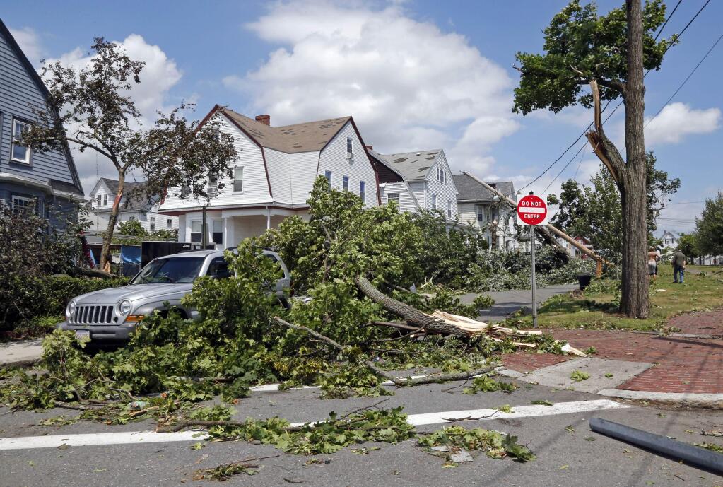 Downed trees and power lines lay in front of homes in Revere, Mass., Monday, July 28, 2014 after a tornado touched down. (AP Photo/Elise Amendola)