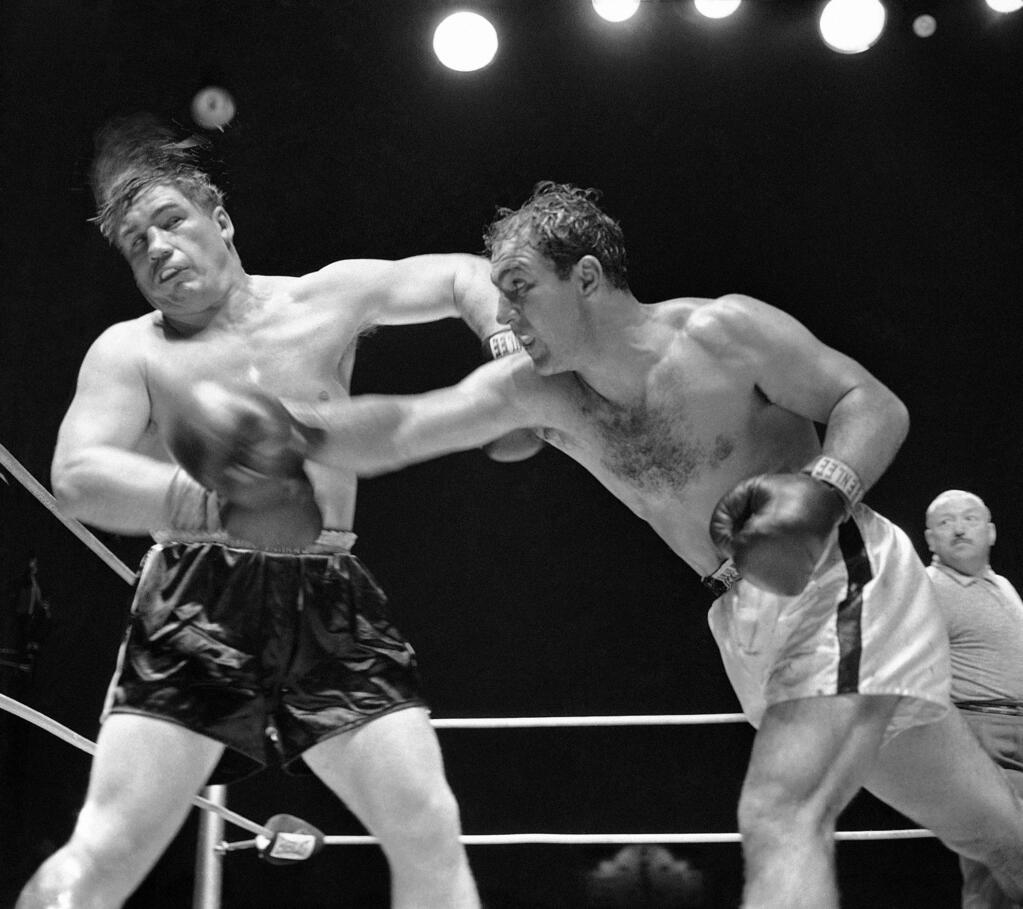 Rocky Marciano, heavyweight champion from Brockton, Mass., rocks challenger Don Cockell with a wicked right in the ninth round of their title bout at Kezar Stadium in San Francisco, May 16, 1955. Rocky kept his title via a TKO when the referee stopped the bout after 54 seconds of the ninth round. (AP Photo)
