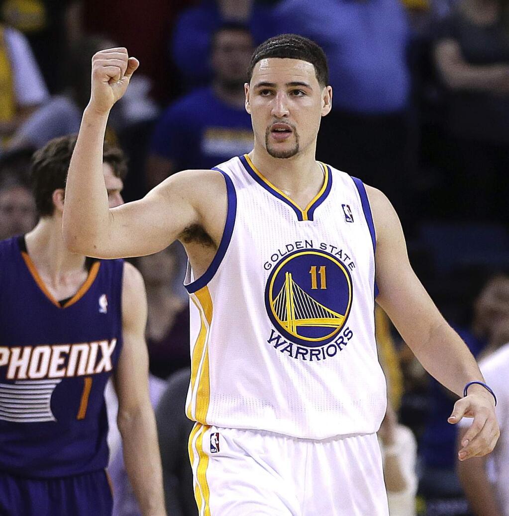 Golden State Warriors' Klay Thompson (11) celebrates a score against the Phoenix Suns during the second half of an NBA basketball game Sunday, March 9, 2014, in Oakland, Calif. (AP Photo/Ben Margot)