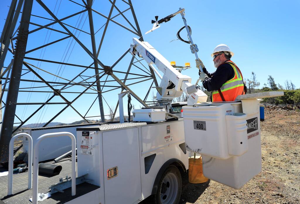 Pacific Gas and Electric communication technicians Mike Fortin prepares to install a wireless solar-powered weather monitoring station on a transmission tower above Pine Flat Road in the Mayacamas Mountains of eastern Sonoma County on Tuesday, July 23, 2019. (KENT PORTER/ PD)