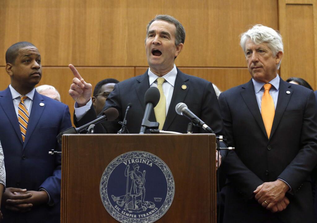 Virginia Gov. Ralph Northam, center, makes remarks as he held a news conference dealing with gun violence while Lt, Gov. Justin Fairfax, left, and Attorney General Mark Herring, right, look on inside the Patrick Henry Building in Richmond, Va. Tuesday, June 4, 2019. Northam is summoning lawmakers back to the state Capitol to consider a package of gun-control legislation after Friday's mass shooting in Virginia Beach. (Bob Brown/Richmond Times-Dispatch via AP)