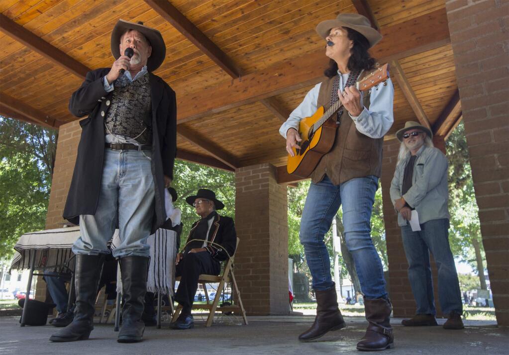 George Webber leads the Bear Flag Acting Troupe in song, while bound members of the Vallejo family listen in the background. Keep your ëso they tortured the prisoners, as well?í jokes to yourself, thank you very much. (Photo by Robbi Pengelly/Index-Tribune)