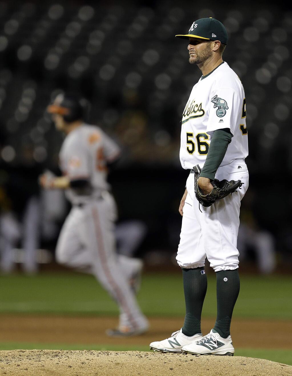 Oakland Athletics pitcher Chris Smith waits for the Baltimore Orioles' Mark Trumbo, left, to run the bases, after Trumbo hit a home run during the sixth inning Thursday, Aug. 10, 2017, in Oakland. (AP Photo/Ben Margot)