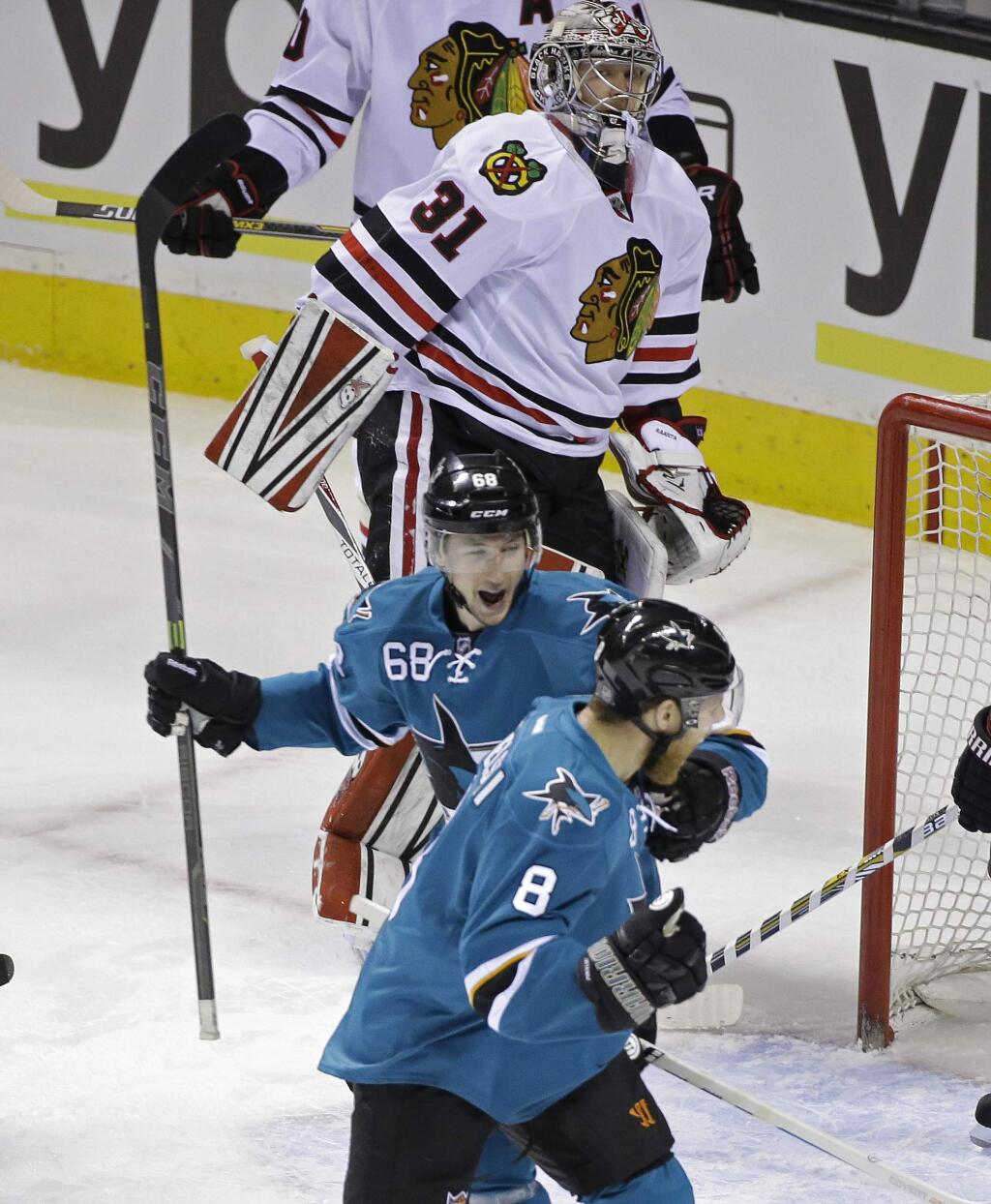 San Jose Sharks right wing Melker Karlsson (68) celebrates with teammate Joe Pavelski (8) after scoring a goal against Chicago Blackhawks goalie Antti Raanta (31) during the first period of their NHL hockey game Saturday, Jan. 31, 2015, in San Jose, Calif. (AP Photo/Eric Risberg)