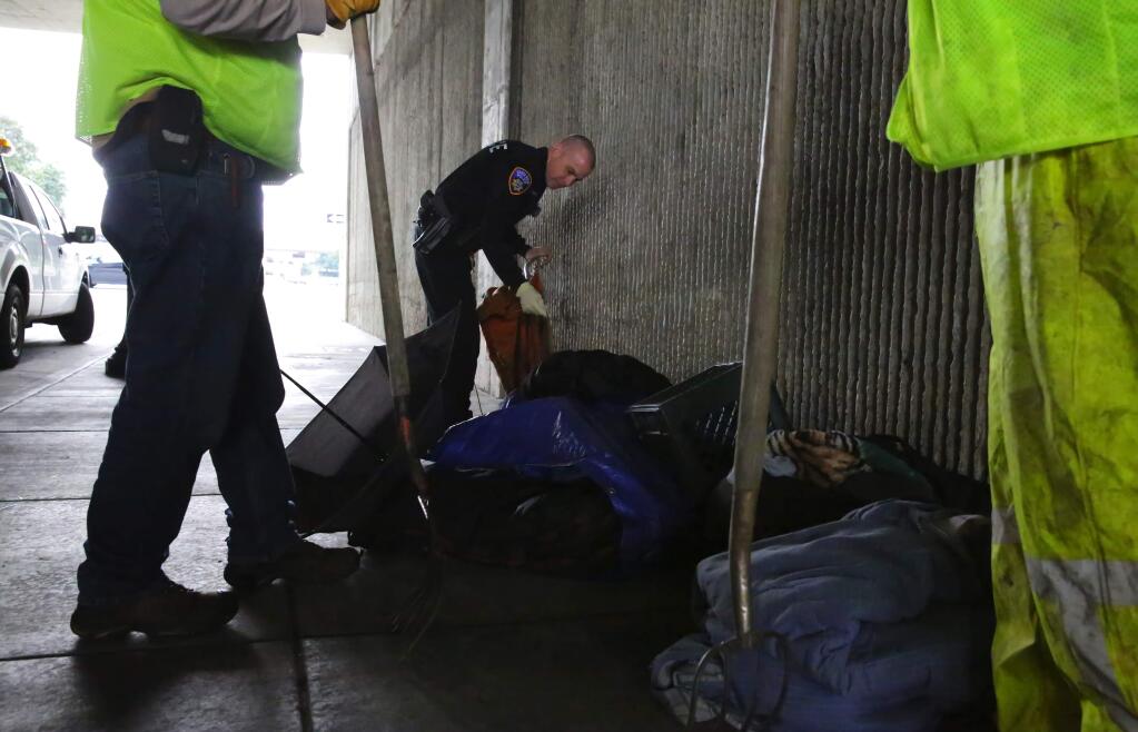 Santa Rosa Police Officer Todd Robert looks through items left by homeless people, during a cleanup of the Sixth Street underpass at Morgan Street on Wednesday, Feb. 1, 2017. (CHRISTOPHER CHUNG/ PD FILE)