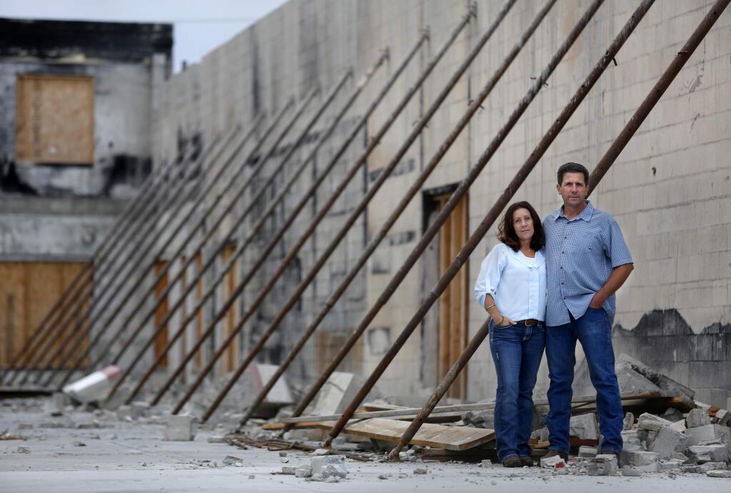 Stacey and Tony Renati stand in the remaining shell of the Frizelle Enos Feeds building, nearly a year after the building burned. They plan to open a new company called The Feed Store. Photo taken in Sebastopol, on Thursday, July 10, 2014. (BETH SCHLANKER/ The Press Democrat)