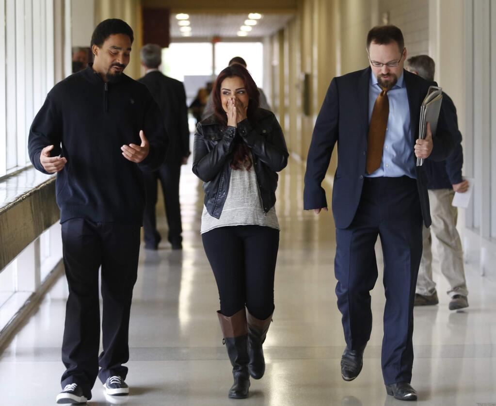 Delia Garcia-Bratcher, joined by her attorney Ben Adams, right, and her fiance Shaka Hay, reacts after Sonoma County prosecutors declined to file any charges against her at the Sonoma County Superior Court in Santa Rosa on Thursday, Aug. 28, 2014. (BETH SCHLANKER/ PD)