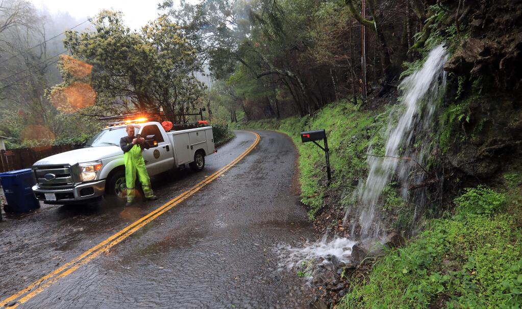 Heavy rain caused a small debris flow on Adobe Canyon Road in Kenwood, Thursday March 22, 2018 in the Nuns fire zone. A county crew was called out to clear the road of rocks and mud. (Kent Porter / Press Democrat) 2018