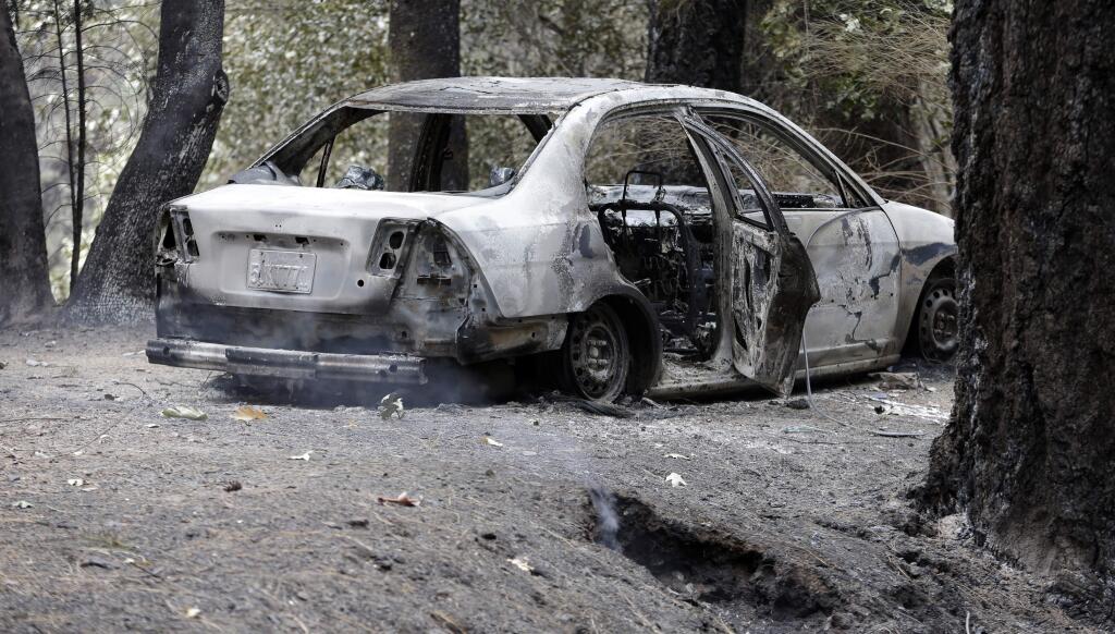 The charred remains of a car belonging to Leonard Neft, who has been missing since a wildfire tore through the area and destroyed his home days earlier, sits in the Anderson Springs area Wednesday, Sept. 16, 2015, near Middletown, Calif. (AP Photo/Elaine Thompson)