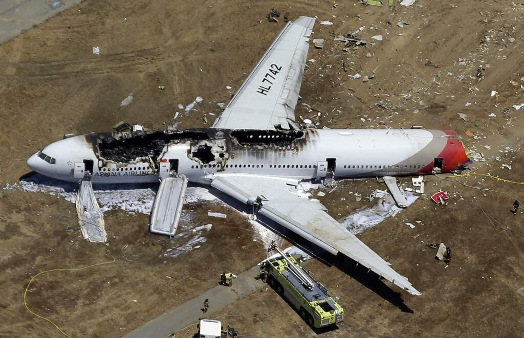 File - In this July 6, 2013, aerial file photo, the wreckage of Asiana Flight 214 lies on the ground after it crashed at the San Francisco International Airport in San Francisco. On Tuesday, March 3, 2015, more than 70 passengers aboard an Asiana Airlines flight that crashed in San Francisco two years ago have reached a settlement in their lawsuits against the airline. (AP Photo/Marcio Jose Sanchez, File)