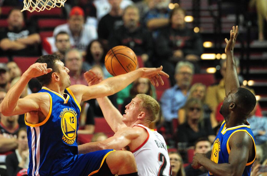 Golden State Warriors center Andrew Bogut (12), Portland Trail Blazers forward Mason Plumlee (24) and Golden State Warriors forward Draymond Green (23) battle for a rebound during the first quarter of an NBA basketball game in Portland, Ore., Thursday, Oct. 8, 2015. (AP Photo/Steve Dykes)